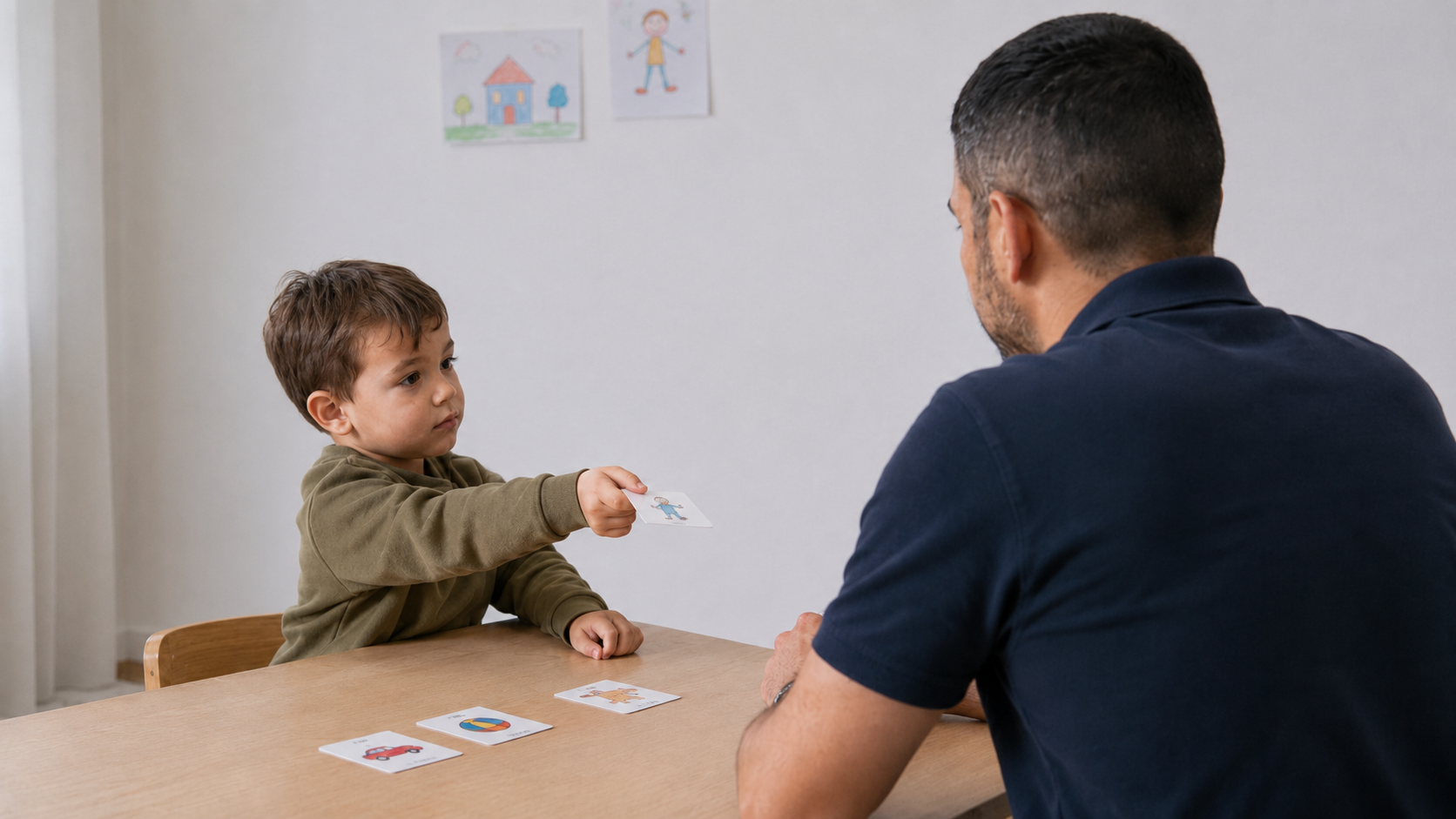 Bambino che consegna un’immagine a un operatore per esprimere una richiesta comunicativa